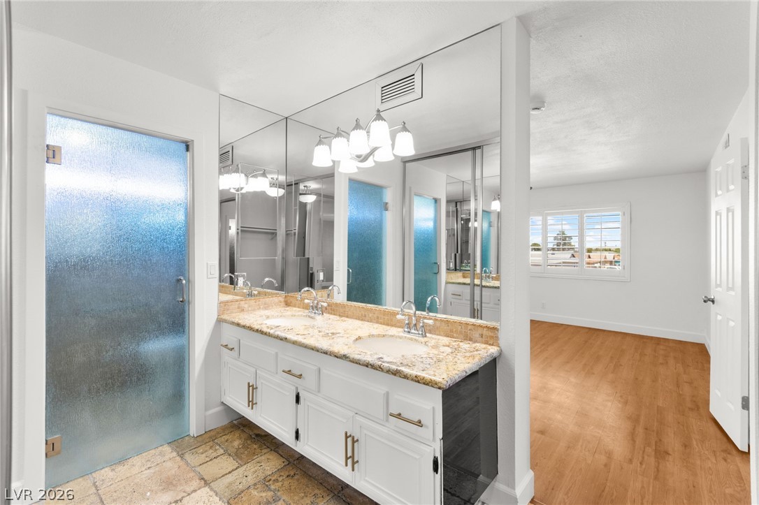 4430 Cranbrook Way Las Vegas, NV 89103 - Photo 38 of 50 Double vanities and reflective wall-to-wall mirrors create a spacious, bright feel in this primary bathroom.