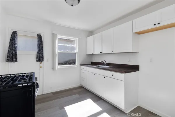 a kitchen with granite countertop white cabinets and black appliances