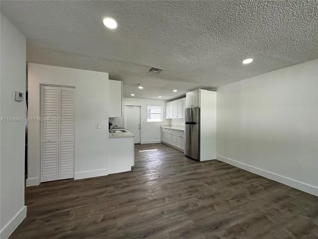 a view of a kitchen with a sink and wooden floor