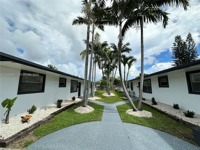 a front view of a house with garden and trees