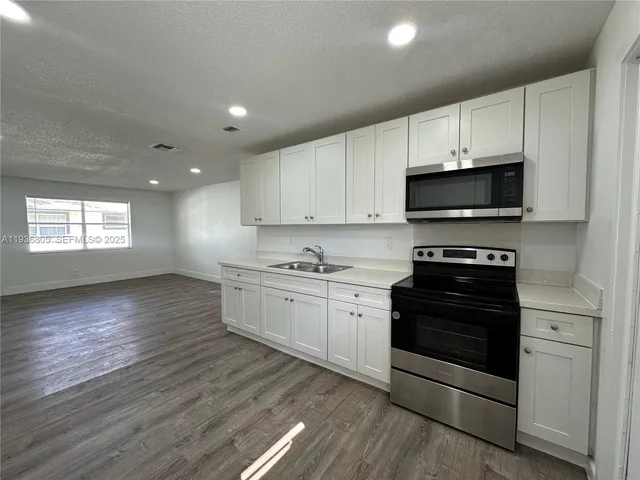 a kitchen with stainless steel appliances a stove a sink and a microwave