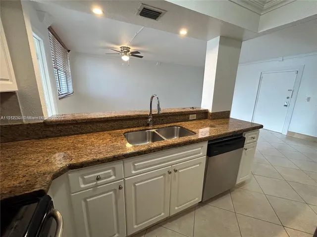 a kitchen with granite countertop a sink and cabinets