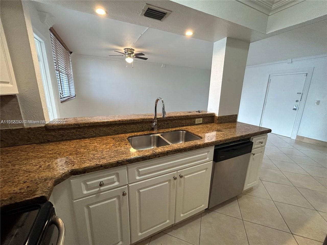 9401 Southwest 4th Street, Unit 111 Miami, FL 33174 - Photo 2 of 12 a kitchen with granite countertop a sink and cabinets