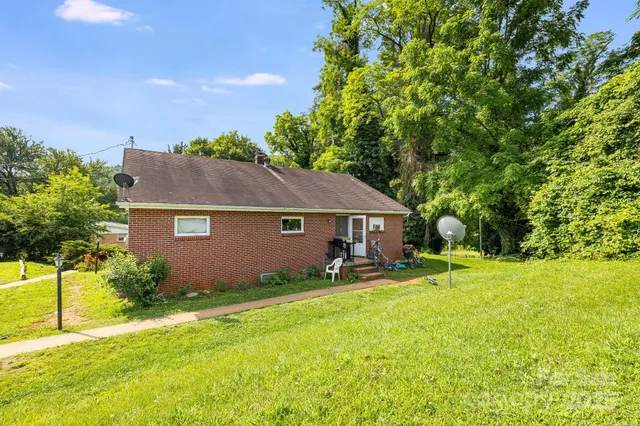 a view of a house with backyard and a tree