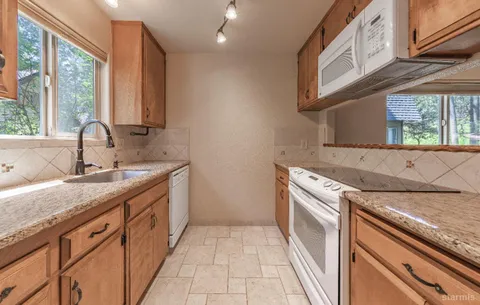 a kitchen with granite countertop a sink and a stove