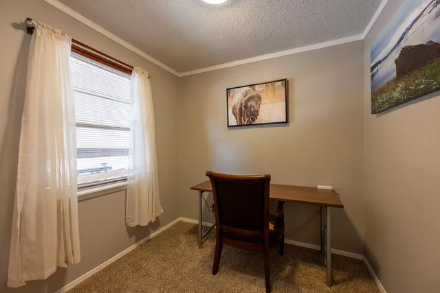 a workspace room with furniture and a window
