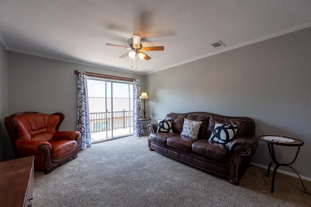 a living room with furniture ceiling fan and a window