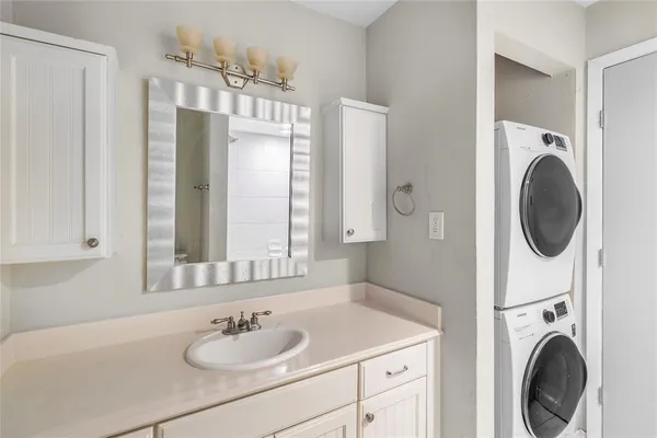 a bathroom with a sink a mirror and a washer dryer