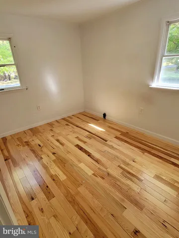 a view of a room with wooden floor and window