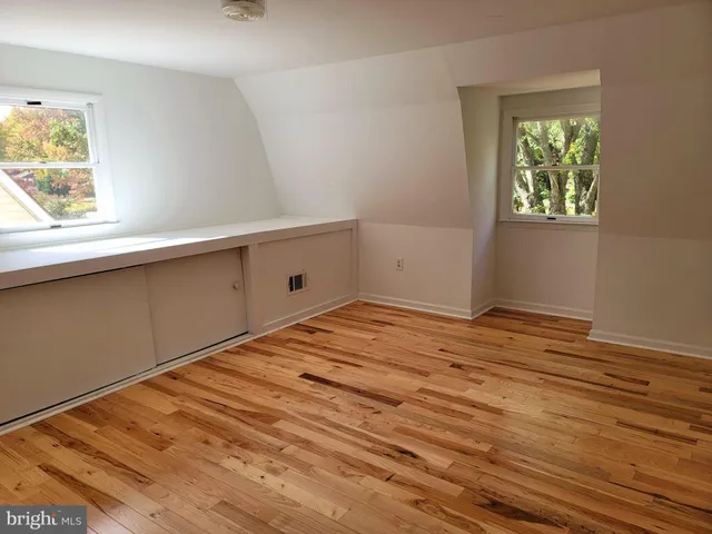 a view of empty room with window and wooden floor