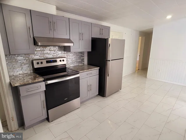 a kitchen with cabinets stainless steel appliances and a counter space