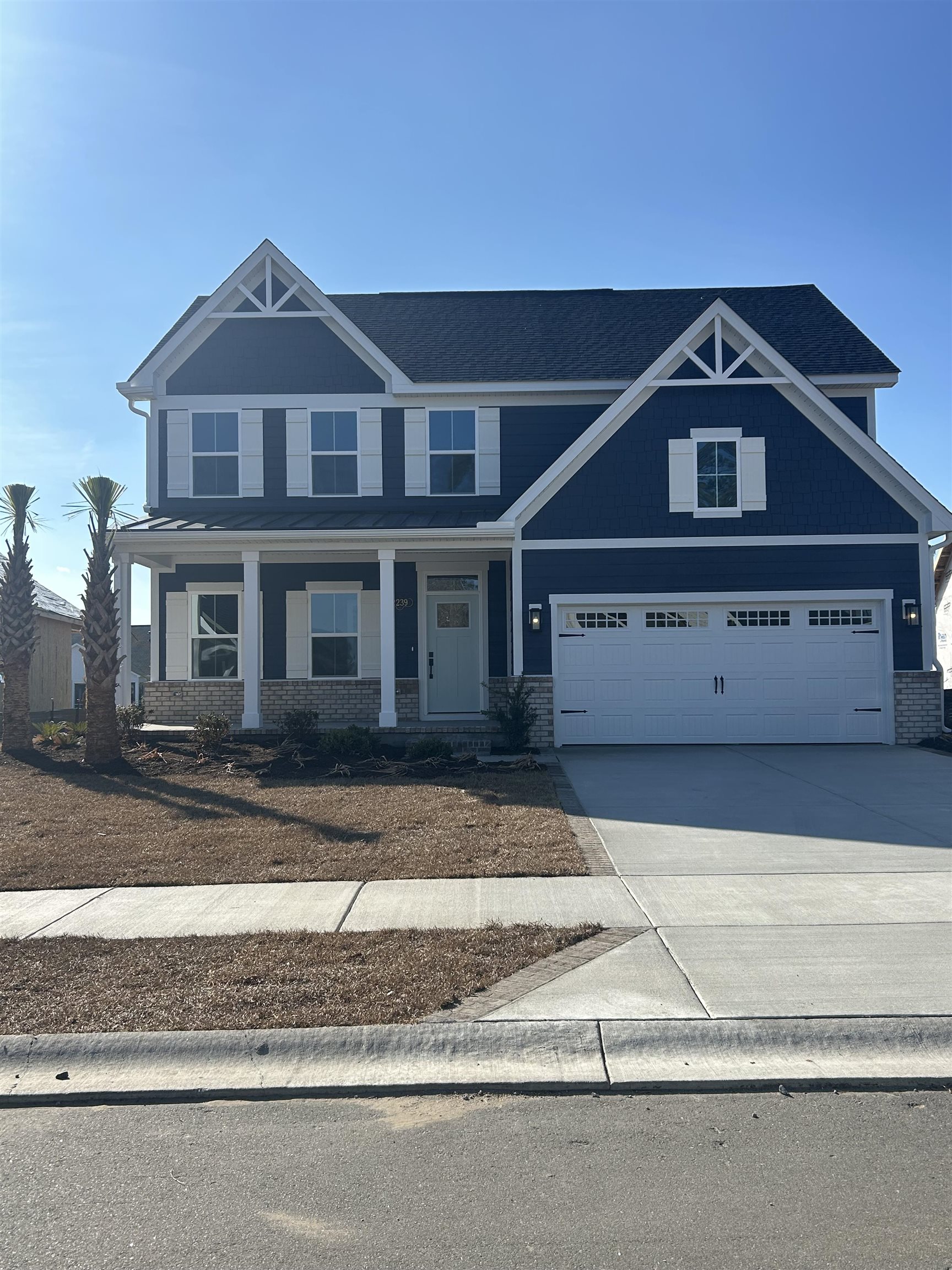 2239 Hazel Way Longs, SC 29568 - Photo 1 of 1 Craftsman-style house with covered porch, concrete driveway, a garage, and brick siding