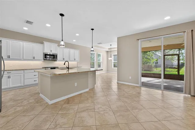 a kitchen with stainless steel appliances granite countertop a sink a oven and a granite counter tops