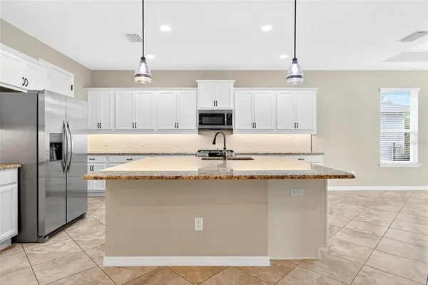 a kitchen with granite countertop a sink a stove and cabinets