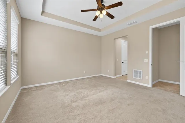an empty room with a window and a fan