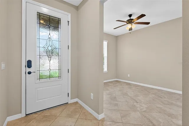 an empty room with a ceiling fan and windows