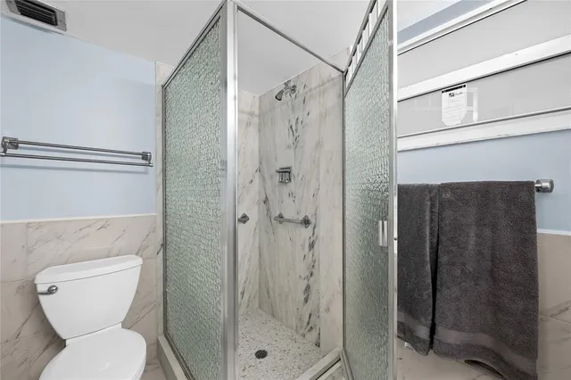 a bathroom with a toilet and a shower
