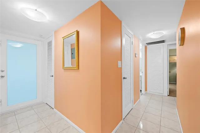 a view of a hallway with closet and bathroom