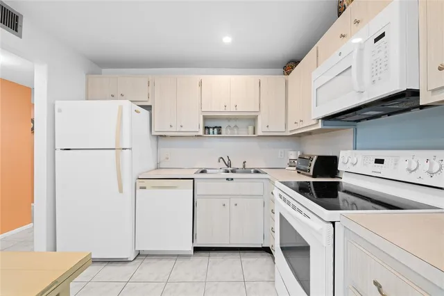 a kitchen with a sink a refrigerator and cabinets