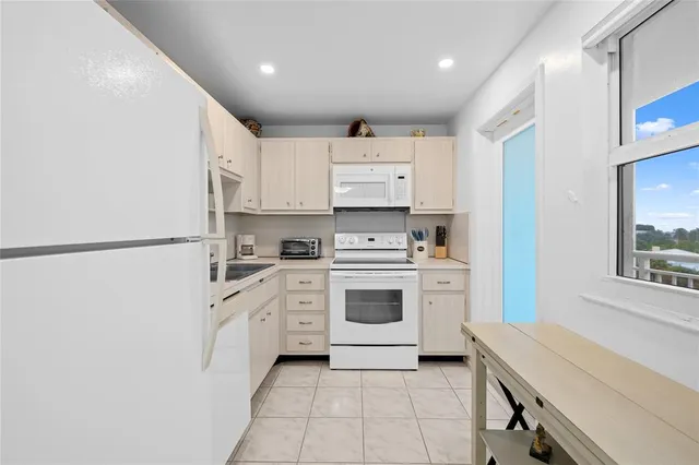 a kitchen with a white cabinets stove and refrigerator