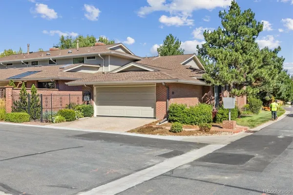 a front view of a house with garage and plants
