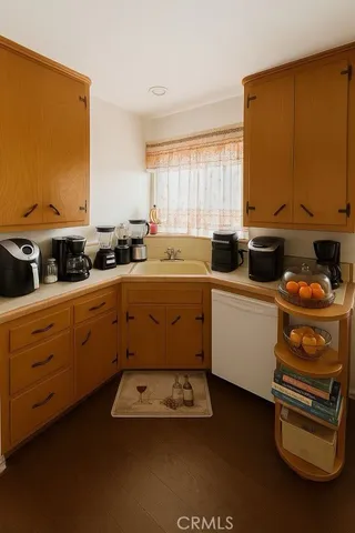 a kitchen with a sink a stove cabinets and a window