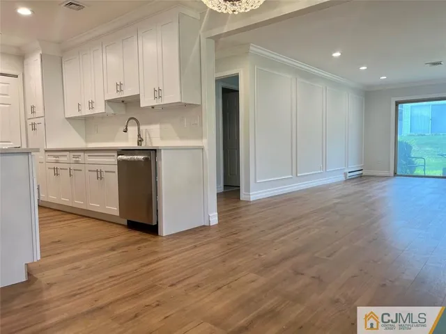 a kitchen with stainless steel appliances granite countertop a white stove top oven and white cabinets