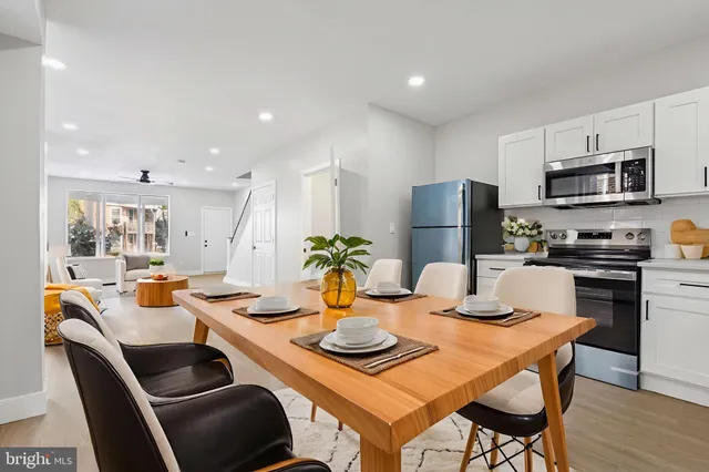 a kitchen with stainless steel appliances kitchen island granite countertop a dining table and chairs