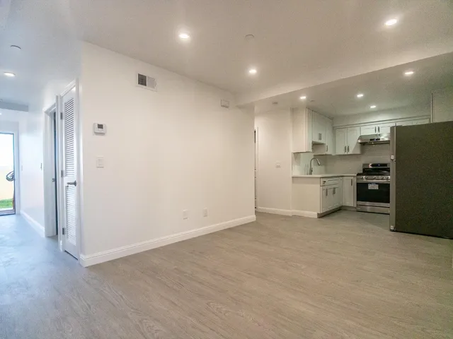 a view of kitchen empty refrigerator and wooden floor