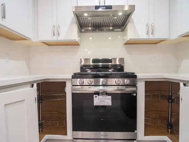 a stove top oven sitting inside of a kitchen