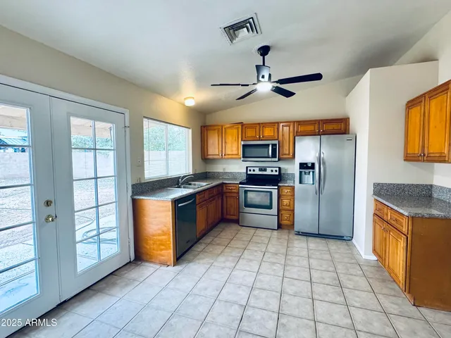 a kitchen with stainless steel appliances granite countertop a stove a sink and a refrigerator
