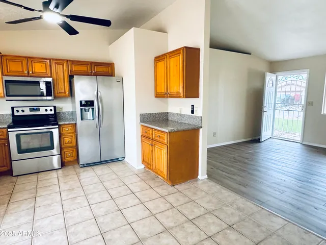 a kitchen with stainless steel appliances granite countertop a stove a sink and a refrigerator