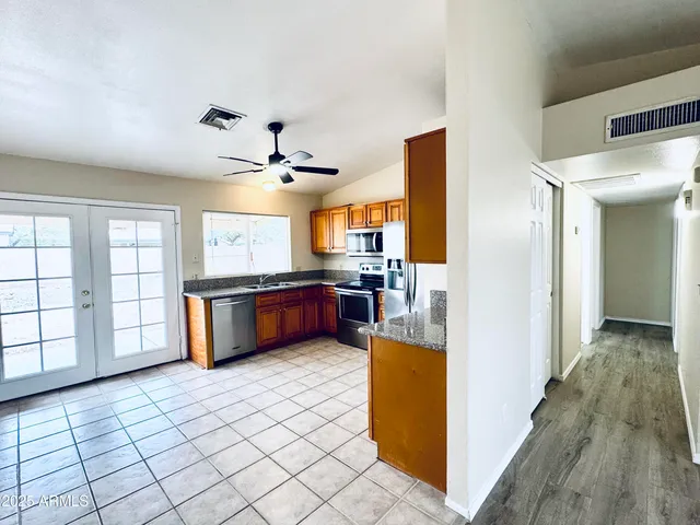 an empty room with wooden floor closet and windows