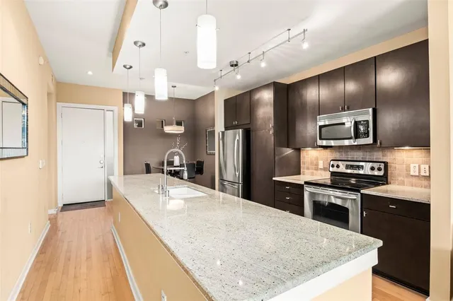 a large kitchen with stainless steel appliances kitchen island granite countertop a large counter top cabinets and stainless steel appliances