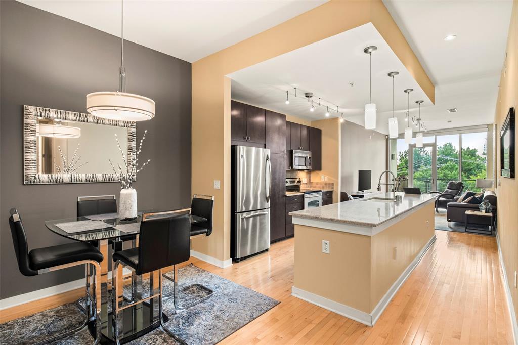 2950 McKinney Avenue, Unit 412 Dallas, TX 75204 - Photo 7 of 26 a kitchen with stainless steel appliances kitchen island granite countertop a sink refrigerator and cabinets