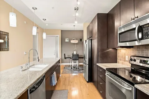 a kitchen with stainless steel appliances a stove a sink a refrigerator and cabinets
