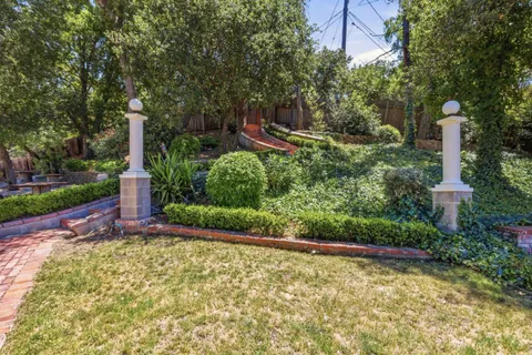 a front view of a house with a yard and shrubs