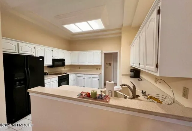 a kitchen with stainless steel appliances a sink a stove a refrigerator a counter top space and cabinets