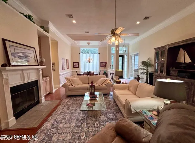 a living room with furniture a fireplace and a chandelier