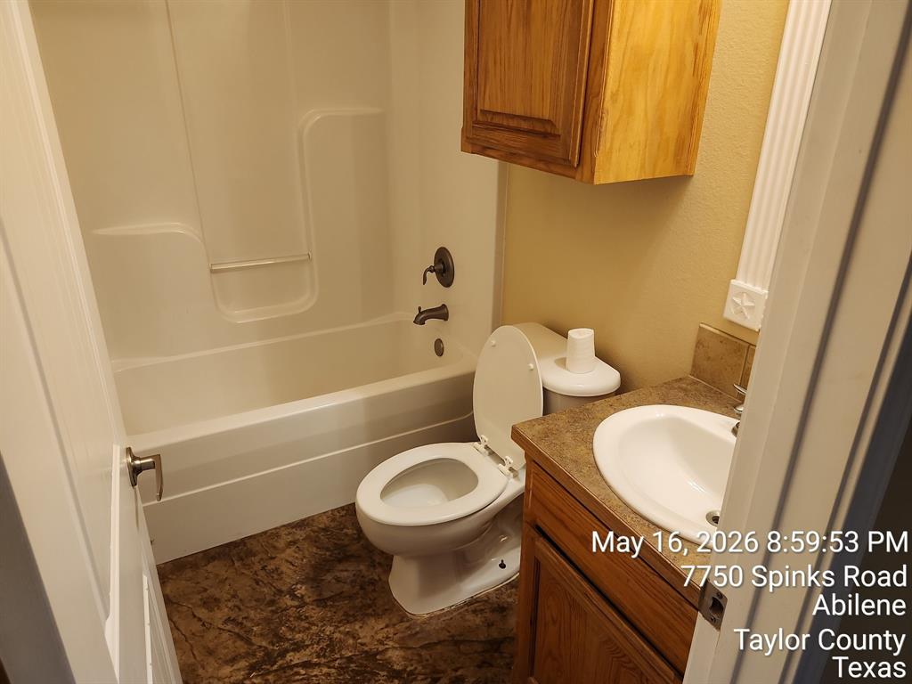 7750 Spinks Road Abilene, TX 79603 - Photo 13 of 15 a bathroom with a granite countertop toilet sink and mirror
