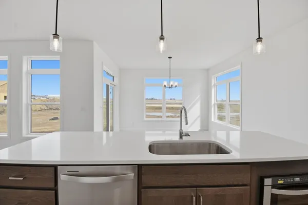 a kitchen with a sink a counter space and wooden floor