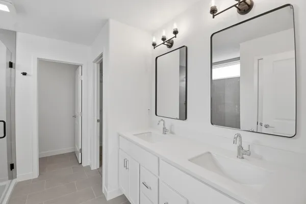 a bathroom with double vanity sinks and a mirror