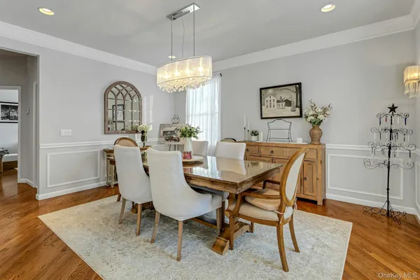 a view of a dining room with furniture a chandelier and wooden floor