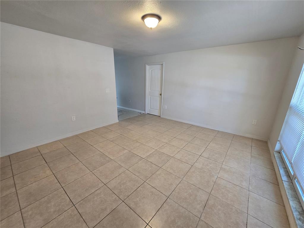 3406 Murrow Street New Port Richey, FL 34655 - Photo 4 of 21 an empty room with white walls and tiles