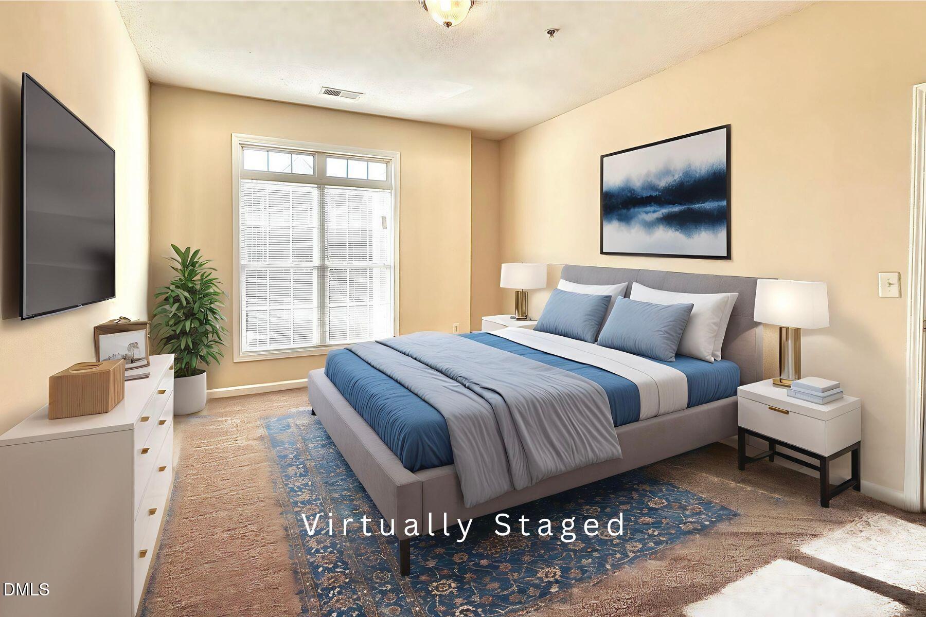 2521 Friedland Place, Unit 201 Raleigh, NC 27617 - Photo 4 of 34 a bedroom with a bed and a flat screen tv