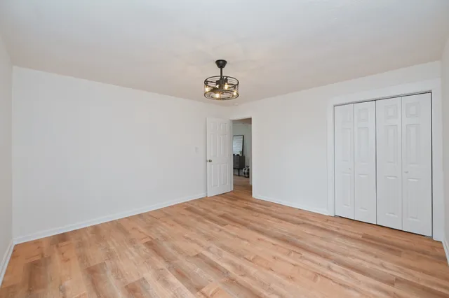 a view of a room with wooden floor and ceiling fan
