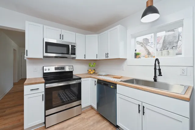 a kitchen with cabinets stainless steel appliances a sink and a counter top space