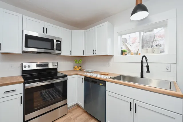 a kitchen with stainless steel appliances granite countertop a sink and a stove