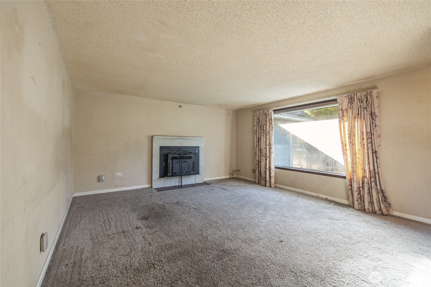 20822 Southeast 271st Street Covington, WA 98042 - Photo 11 of 30 an empty room with a fireplace and windows
