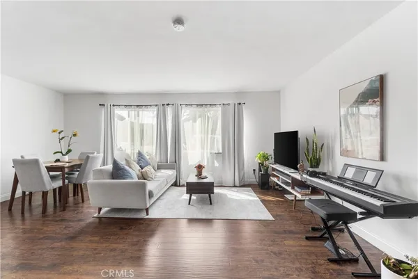 a living room with furniture flat screen tv and a large window